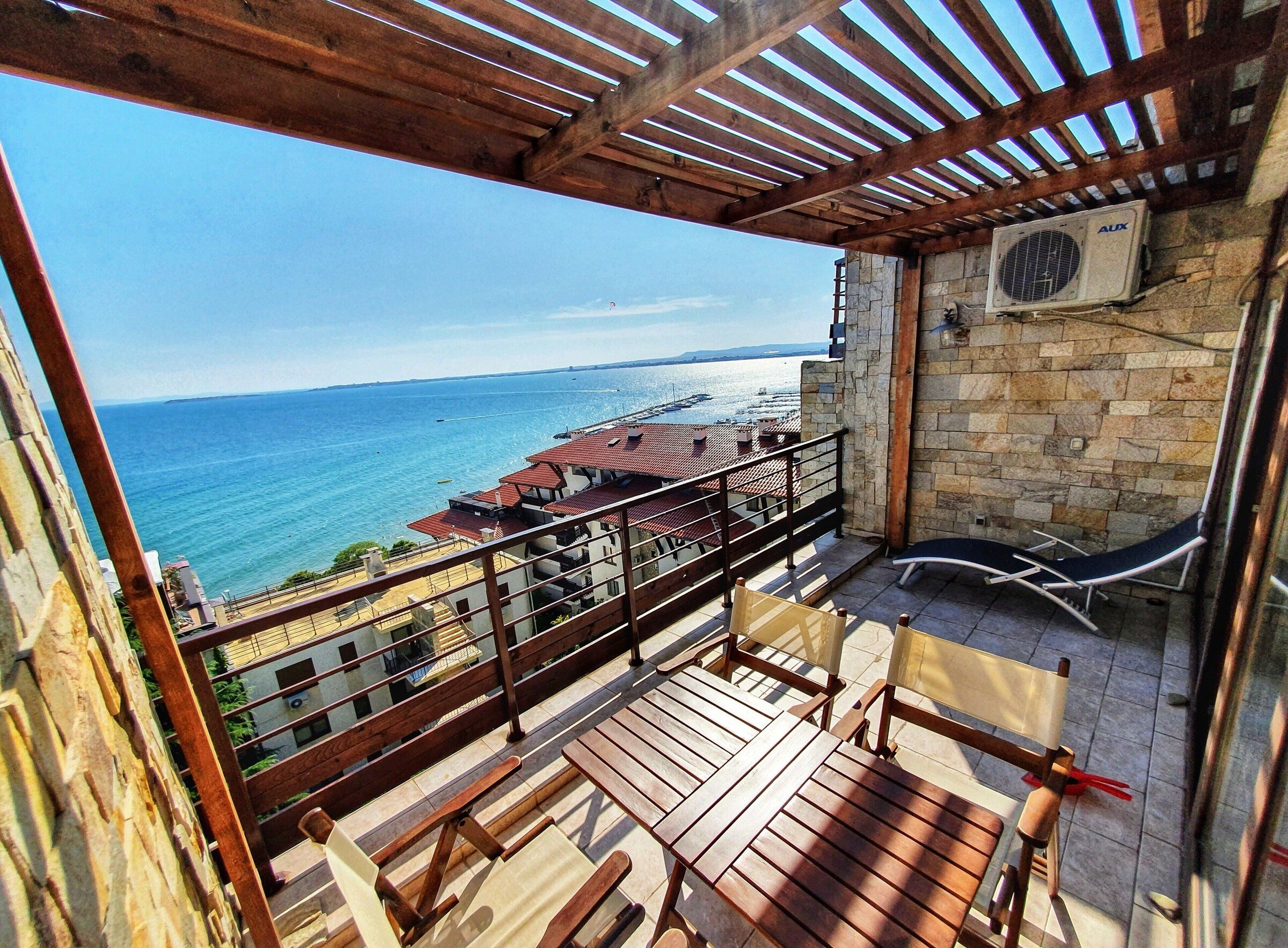 Penthouse terrace at golden hour with sea and marina views